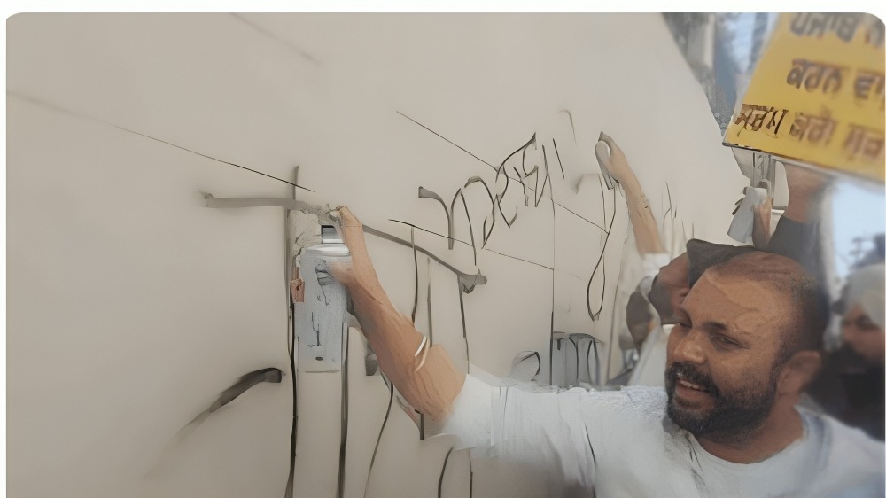  दीवार पर लिखते हुए आम आदमी पार्टी कार्यकर्ता। Photo Credit: Screengrab