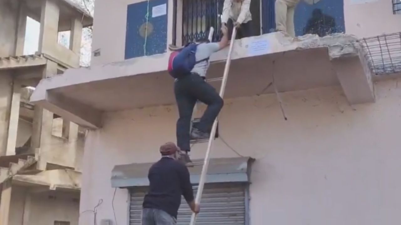 एसबीआई भद्रक ब्राचं पर सीढ़ी लगाकर चढ़ते लोग । Photo Credit: Screengrab