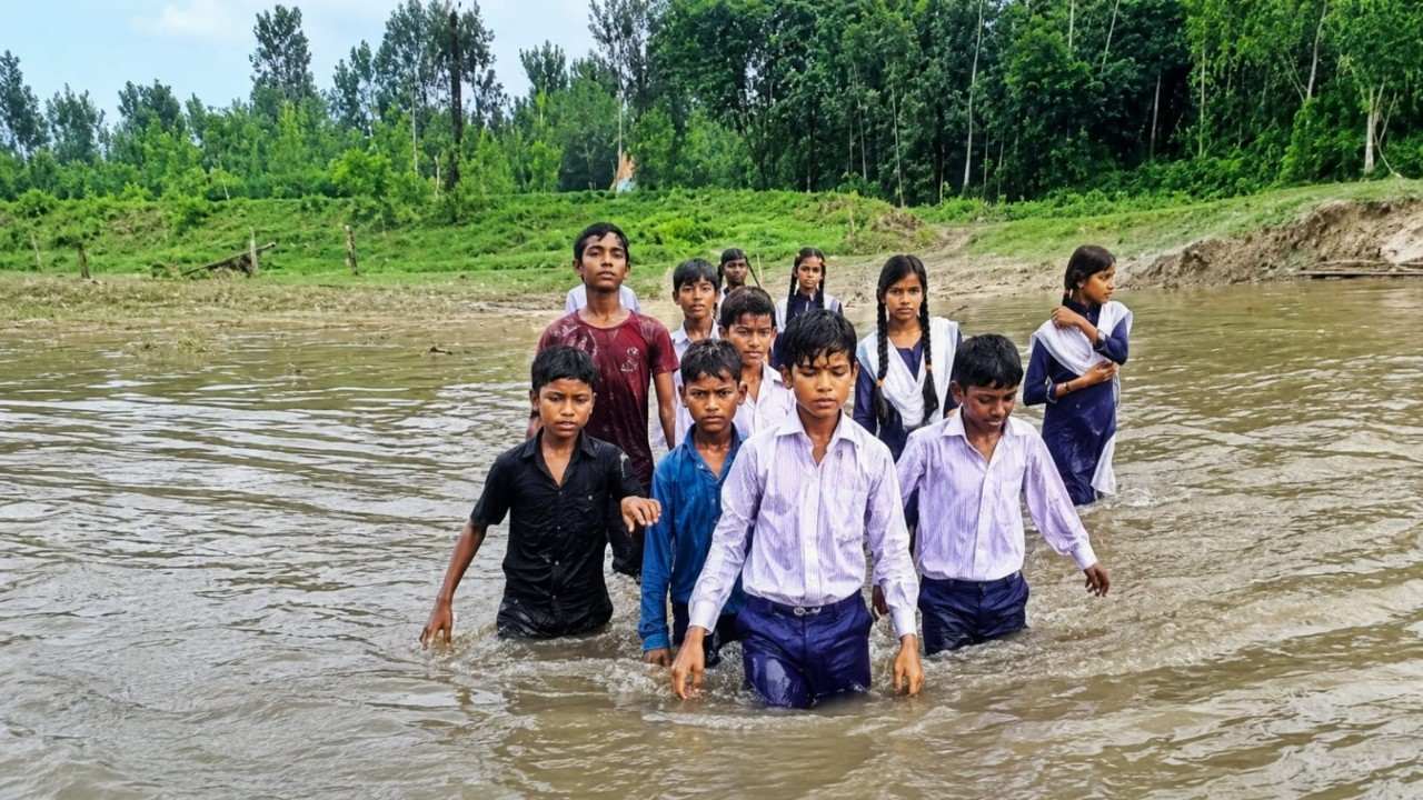 घूघा नदी के अंदर खड़े होकर प्रदर्शन करते छात्र- छात्राएं। Photo Credit: Social Media