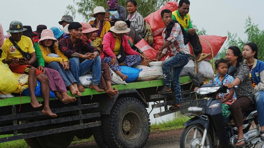 Cambodians sit on a cart of a tractor as they take refuge